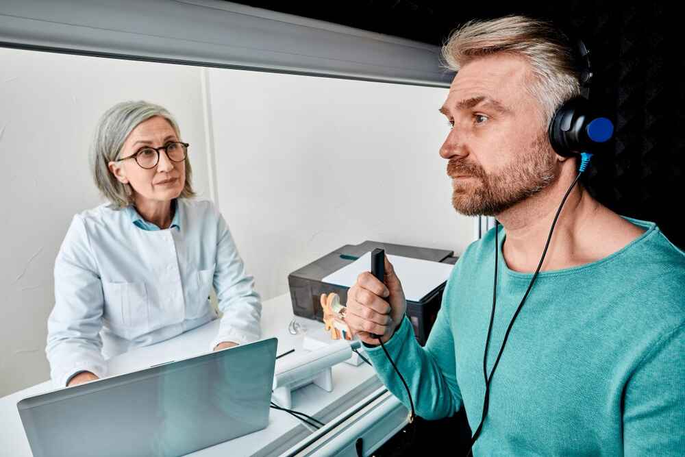 Man completing a hearing test with an audiologist