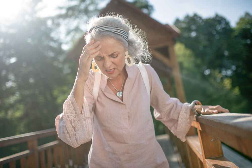 Older woman experiencing dizziness and balance issues while walking outside